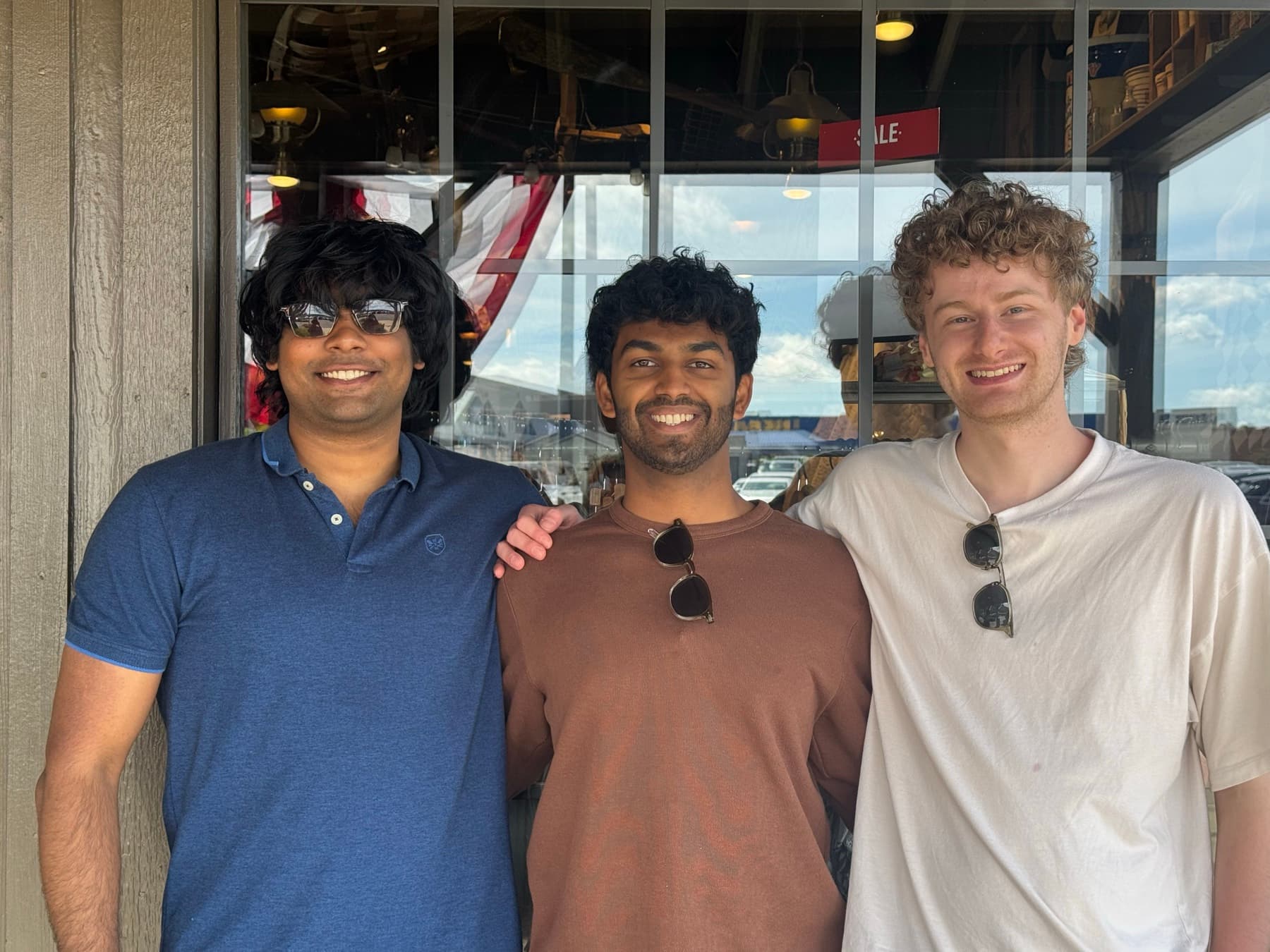 The three founders of Janus Labs standing together, smiling. From left to right: Akshat, Atharva, and Ben